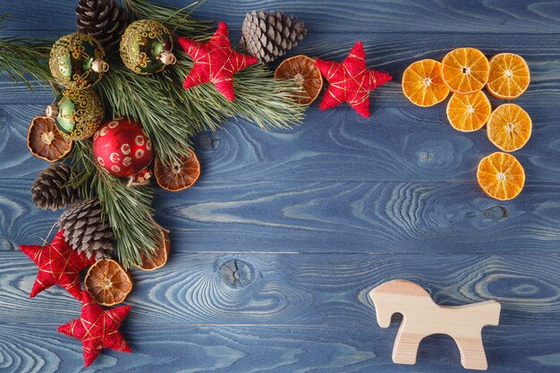 Mesa de madeira rústica de Natal ou ano novo com enfeites de brinquedo e galho de árvore de peles, vista superior, copie o espaço