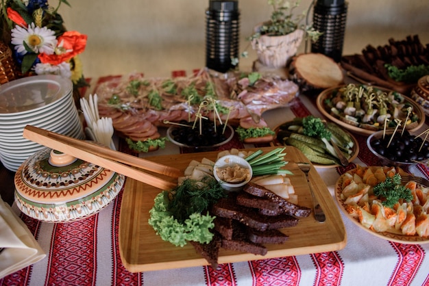 Mesa de madeira servida com pano bordado e salgados