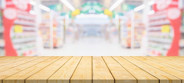 Foto mesa de madeira vazia com corredor de supermercado e prateleiras de fundo desfocado