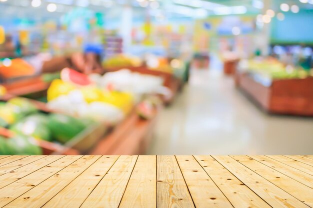 Foto mesa de madeira vazia com fundo desfocado de supermercado para exibição de produtos