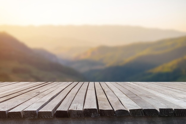 Mesa de madeira vazia na frente da bela vista de pastagem borrada e montanha com belo fundo do nascer do sol da natureza pode ser usado para exibição ou montagem para mostrar seus produtos