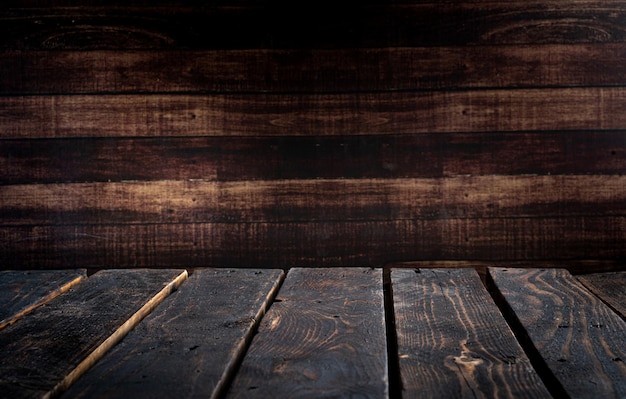 Mesa de madeira vazia no fundo escuro da parede de madeira temperamental premium photo