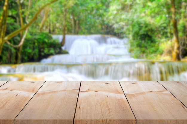 Foto mesa de madeira vazia para exibição do produto com tema ao ar livre no fundo da cachoeira desfocada