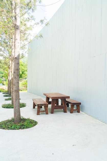 Mesa de madeira vazia para pátio externo e cadeira com parede branca
