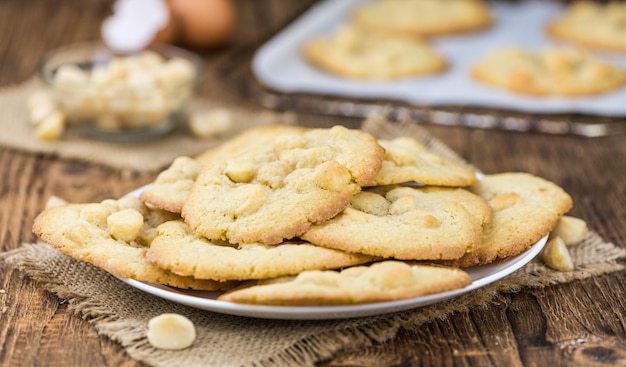 Mesa de madeira velha com biscoitos de macadâmia frescos com foco seletivo