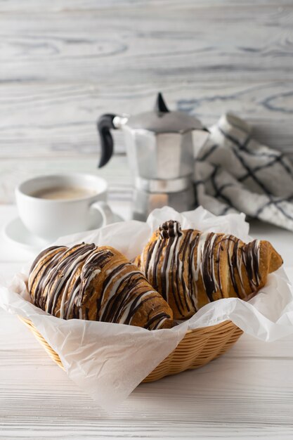 Mesa de manhã com café, croissants frescos com chocolate