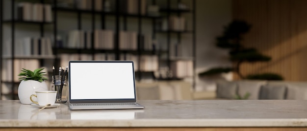 Mesa de mármore com maquete de laptop sobre sala de estar turva com estantes em segundo plano