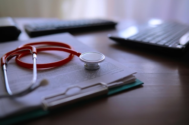 Mesa de médicos no escritório da clínica Tubos de ensaio de estetoscópio prescrições de laptop em cima da mesa