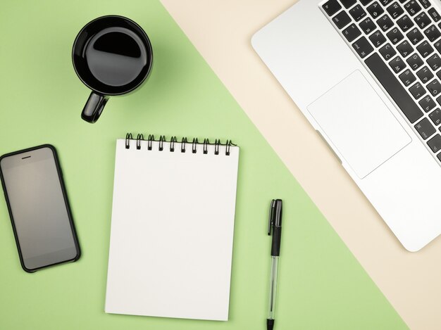 Mesa de mesa de escritório moderno com laptop, página de caderno em branco