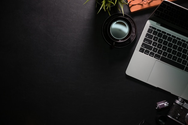 Mesa de mesa de espaço de trabalho de escritório preto com laptop, material de escritório e espaço de cópia