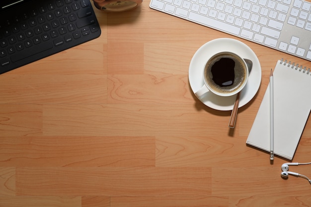 Mesa de mesa de madeira de escritório com computador, xícara de café e espaço de cópia