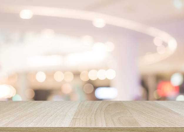 Mesa de mesa de madeira em borrão com bokeh shopping mall background - pode ser usado para exibir ou montar seus produtos