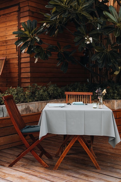 Mesa de mesa e cadeiras de madeira em um restaurante ao ar livre de verão