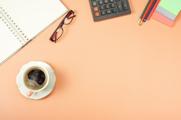 Mesa de mesa elegante, espaço de trabalho. local de trabalho no escritório com mesa moderna. vista de cima da calculadora com o bloco de notas e café.