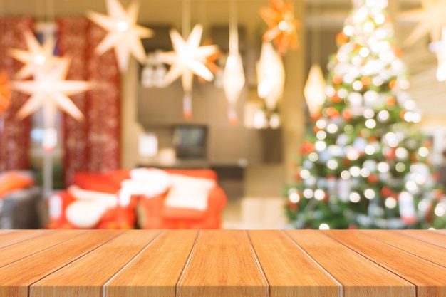 Foto mesa de mesa vazia em árvore de natal borrada e fundo de lareira