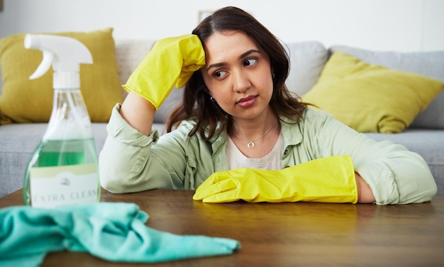 Mesa de mulher e pensando em limpar o estresse doméstico e cansado com pano de luvas e produto químico Idéias de menina e fadiga com bactérias em spray ou sentada na sala com ansiedade por higiene