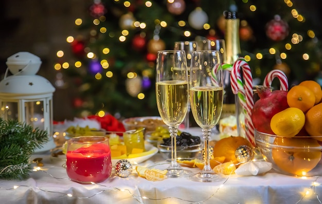 Mesa de Natal com champanhe e comida. Foco seletivo. Feriado.