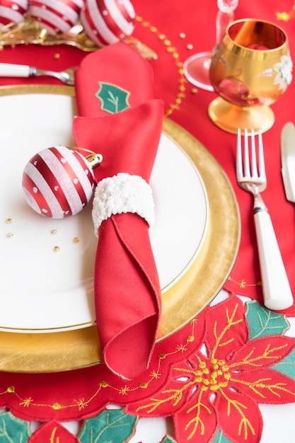 Mesa de Natal com prato branco e dourado, faca e garfo close-up