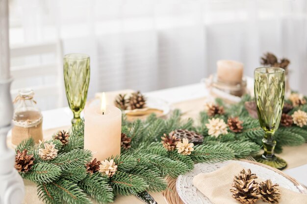 Mesa de natal com ramos de abeto, pinhas e vela acesa