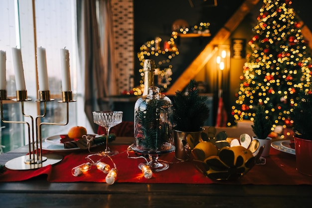 Mesa de Natal festiva na cozinha com uma grande árvore de Natal e enfeites.