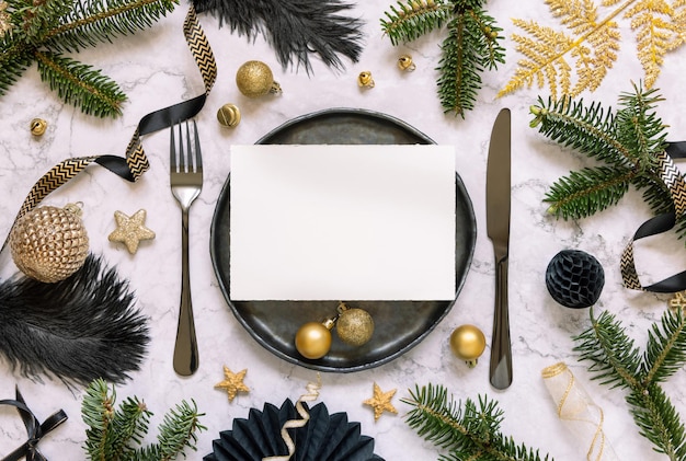 Mesa de natal preta e dourada com enfeites de cartão e galhos de árvores de abeto mockup