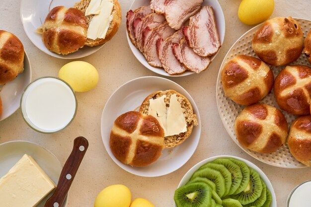 Mesa de Páscoa com cruz pães e ovos amarelos coloridos