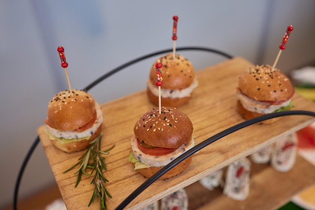 Mesa de recepção buffet com hambúrgueres frios de carnes e saladas