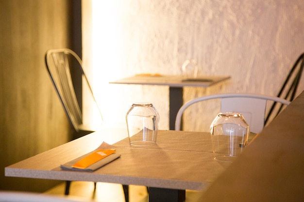 Mesa de restaurante elegante com talheres, louças e copos.