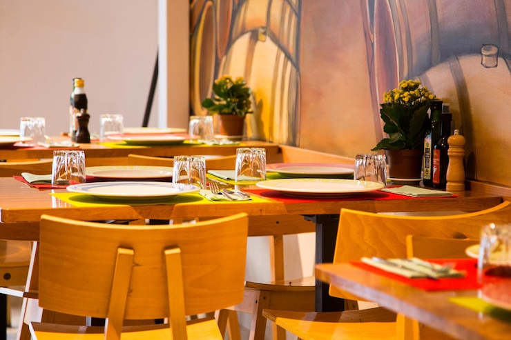 Foto mesa de restaurante elegante com talheres, louças e copos.