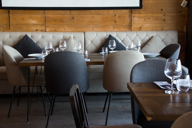 Mesa de restaurante elegante com talheres, louças e copos.