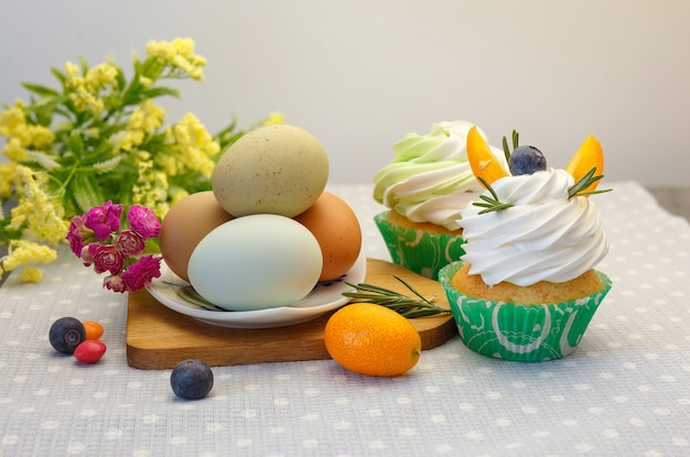 Mesa de sobremesa do feriado da Páscoa com cupcakes, ovos e doces.