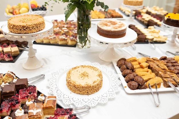 Foto mesa de sobremesas com vários doces, café e bolos de nozes