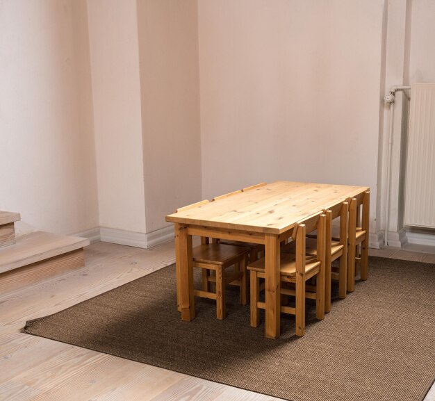 Mesa de tamanho infantil e seis cadeiras em sala de aula