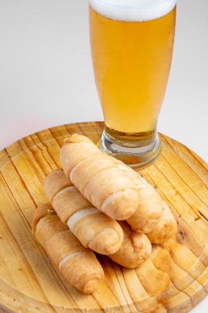 Foto mesa de tequeos com copo de cerveja gelada