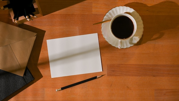 mesa de trabalho com cartão, xícara de café e papelaria na sala de home office