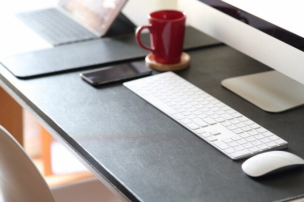 Mesa de trabalho com computador e material de escritório