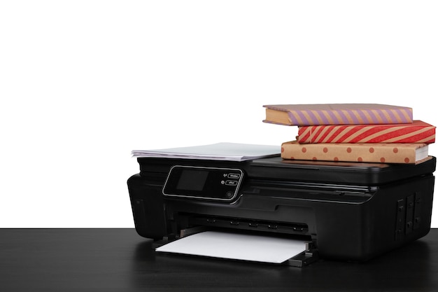 Mesa de trabalho com impressora e livros empilhados no fundo branco