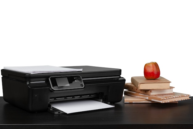 Mesa de trabalho com impressora e livros empilhados no fundo branco