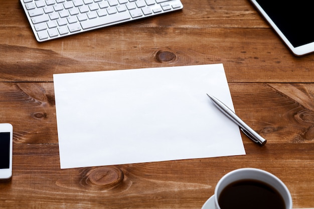 Foto mesa de trabalho com o caderno em branco aberto para anotações na mesa de madeira marrom