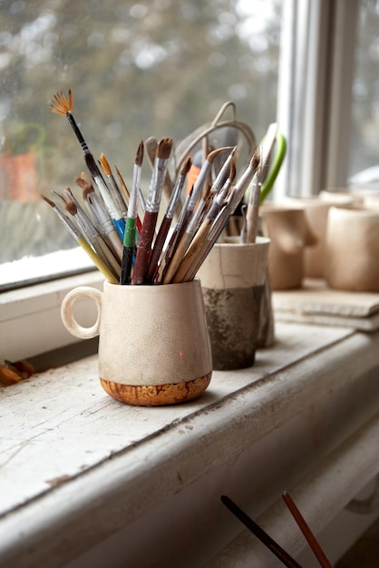 Foto mesa de trabalho de um ceramista. oficina de barro. o processo de criação de cerâmica. a mestre ceramista trabalha em seu ateliê