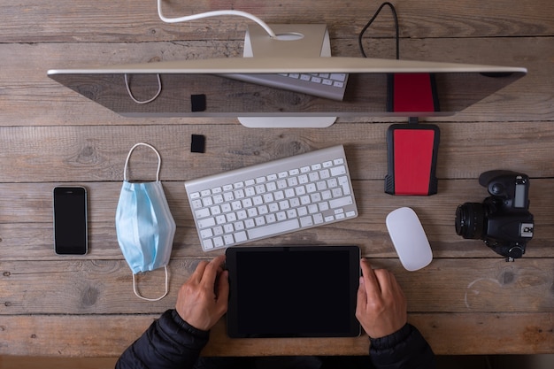 Mesa de trabalho de um fotógrafo latino visto de cima no novo normal.