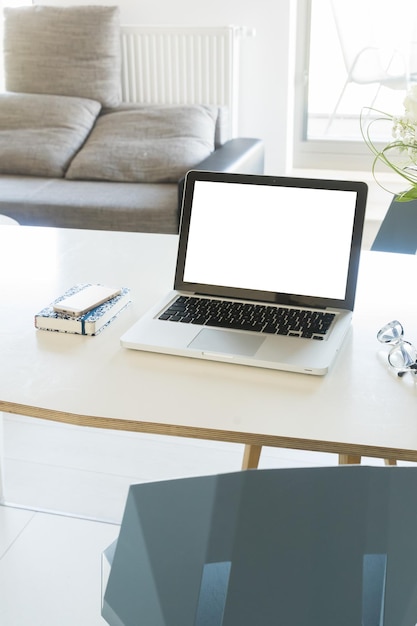 Mesa de trabalho em apartamento com espaço de cópia de laptop em tela em branco