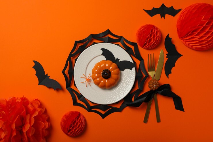 Mesa para decoración de Halloween con arañas y calabazas.