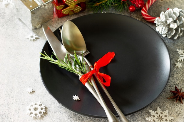 Mesa de decoración navideña Plato y cubiertos negros festivos con decoración navideña