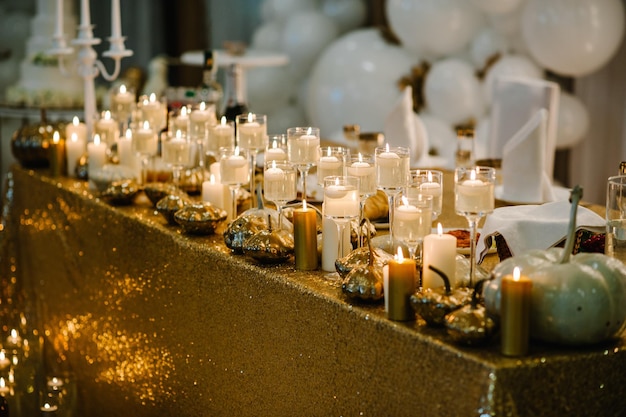 Mesa decorada para boda Globos blancos velas hojas de otoño y calabazas pequeñas Lugar de otoño y decoración de Halloween Ambiente