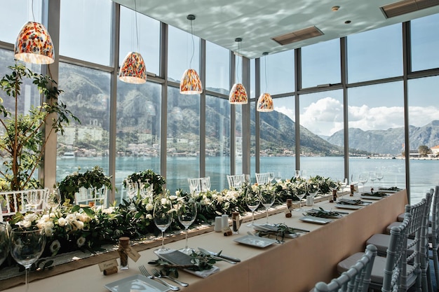 Mesa decorada para una boda con vistas al mar a través de las ventanas