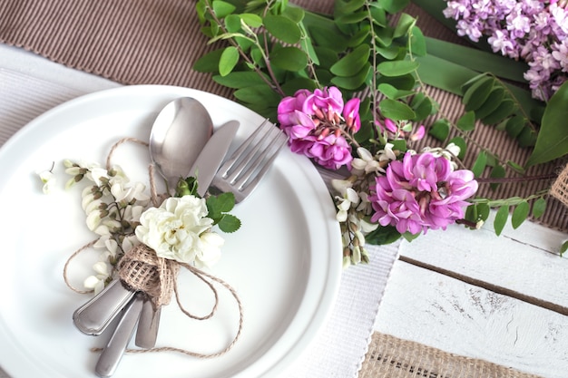 Mesa decorada maravillosamente elegante para las vacaciones: boda o día de San Valentín con cubiertos modernos, moños, vasos, velas y regalos