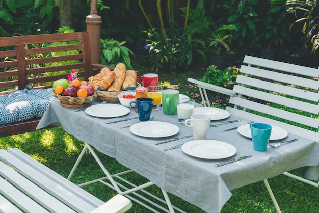 Mesa de desayuno con comida en el jardín.