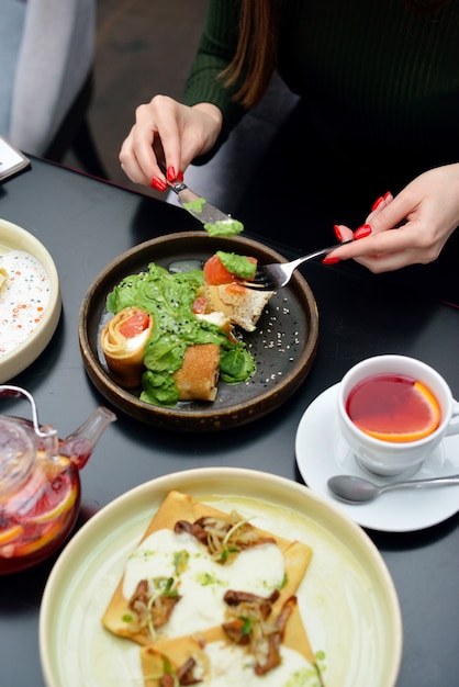 Mesa de desayuno con panqueques, té. Pareja está comiendo