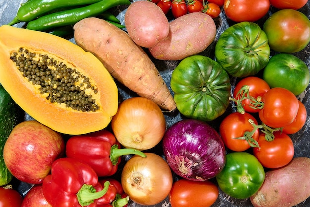 Mesa con diferentes verduras y frutas frescas. Papaya, tomates, pimientos, cebollas y dulce p